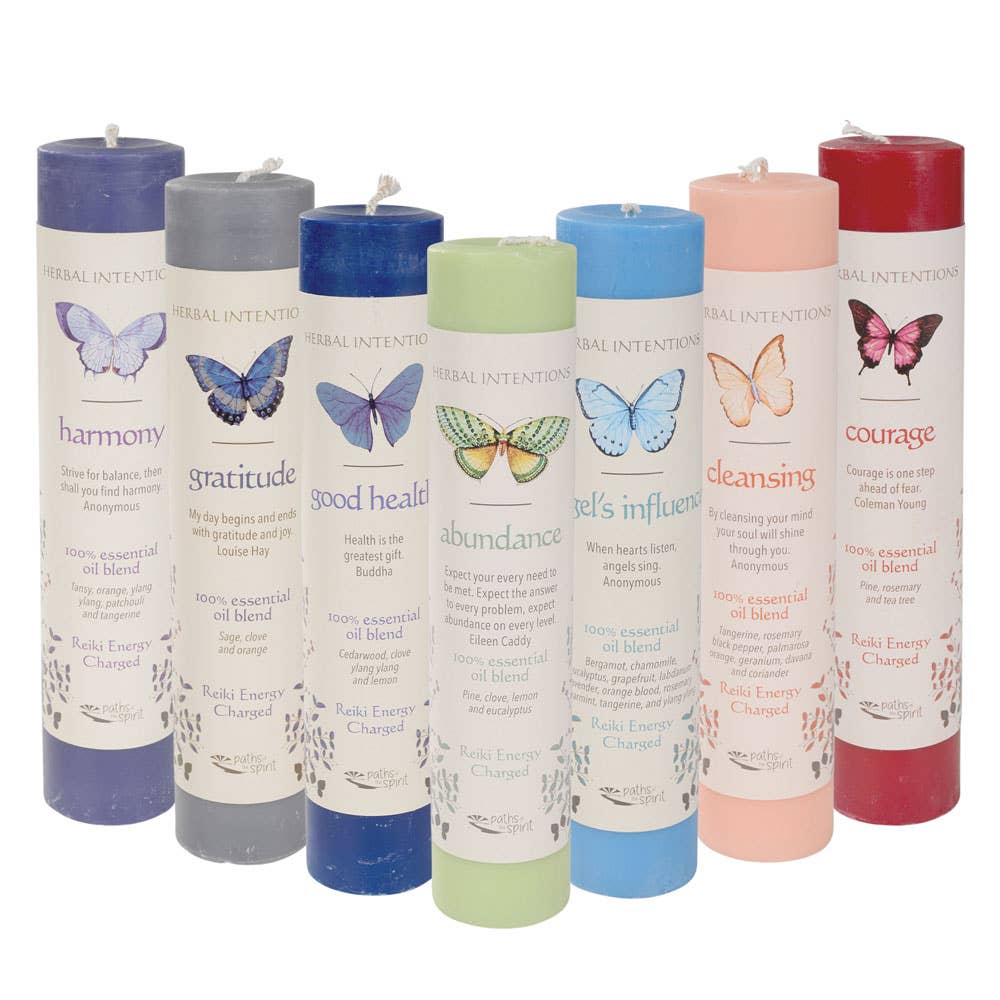Set of Herbal Intention Pillar Candles with colorful labels and butterfly illustrations on a white background