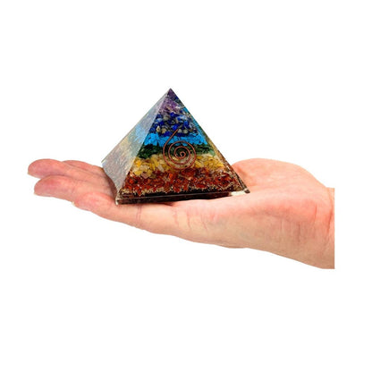 Colorful pyramid stone held in a hand on a white background