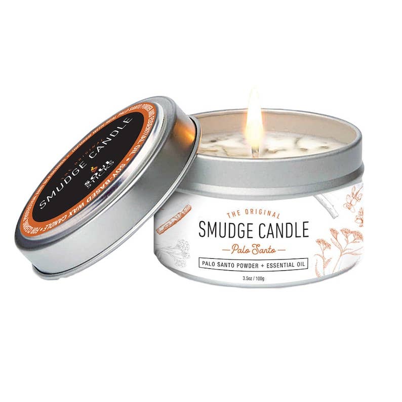 Palo Santo Smudge candle in a tin with a lit candle inside, on a white background