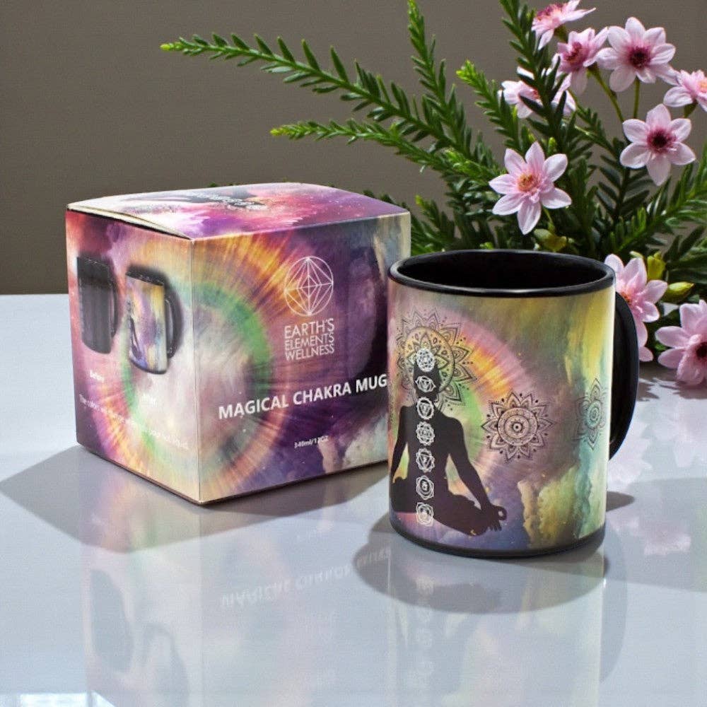 Magical Chakra mug with packaging and flowers on a reflective surface