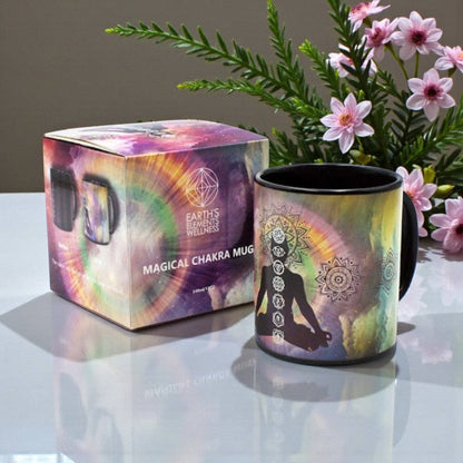 Magical Chakra mug with packaging and flowers on a reflective surface