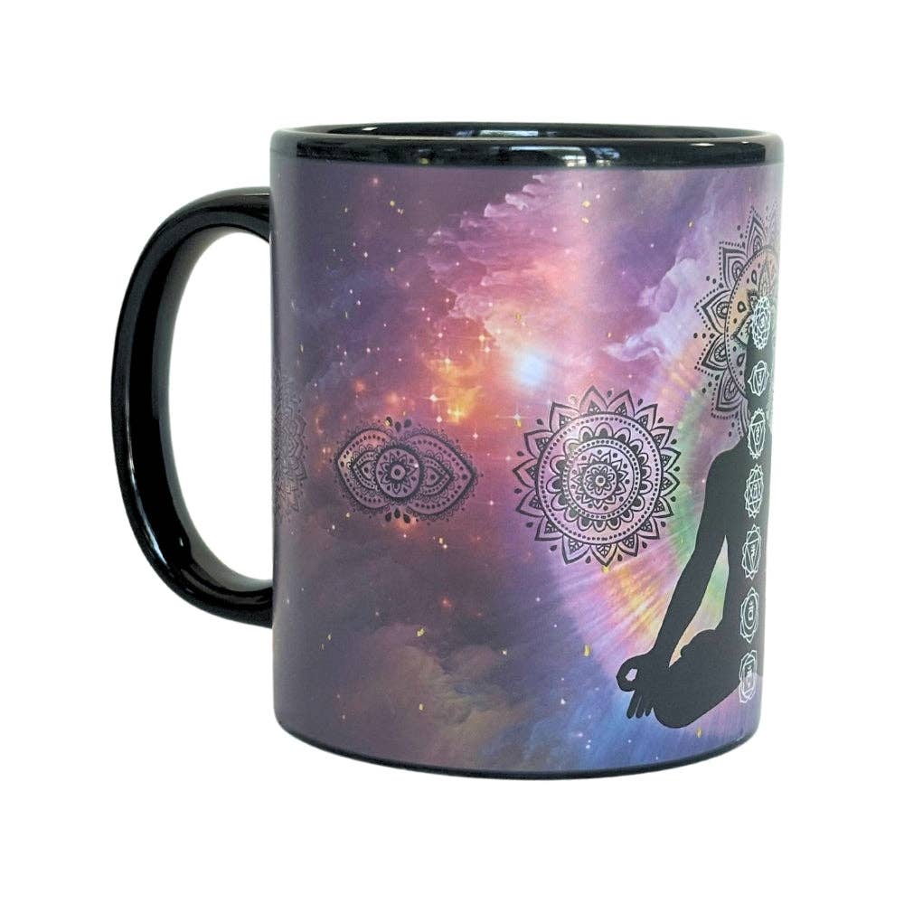 Chakra art Mug with a cosmic design featuring a silhouette of a person meditating and mandalas. Changes colors with hot beverage.