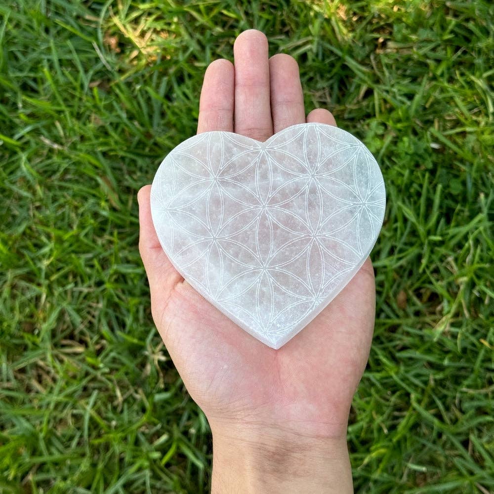 selenite heart flower of life charging plate 4 inch diameter held in palm of hand